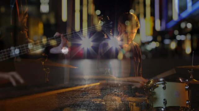 Drummer starting playing camera overlaying city lights over keyboard and bass creating music mood