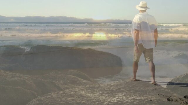 Man walking right on rocks sun sparking overlay mixing surf sun stopping viewing sea for travel
