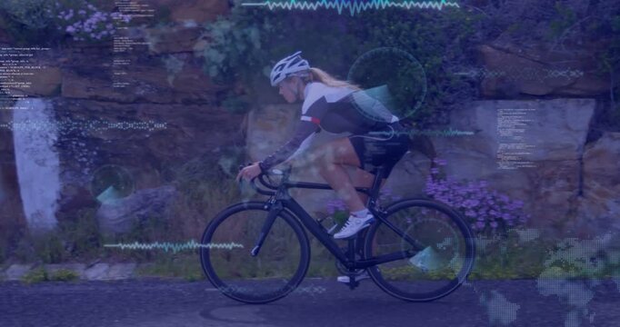 Riding woman pedaling road bicycle by rock wall on paved road wearing helmet jersey showing overlay