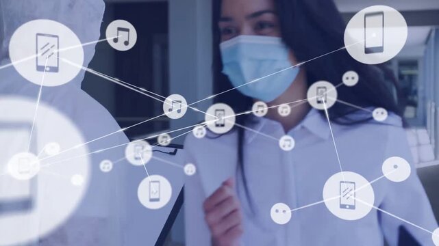 Masked woman showing phone, icons spreading while screener scanning man forehead checking temp