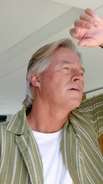 Vertical video: Reacting to sun man in green shirt raising arm checking watch leaning on doorpost