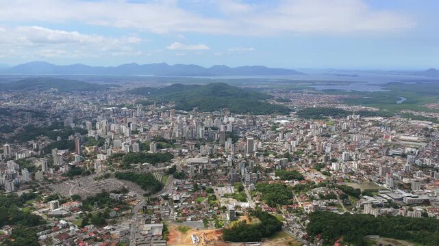 Wide aerial view of Joinville city with urban density, green areas and Babitonga Bay in southern Brazil.