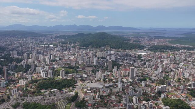 Aerial view of Joinville city with dense urban area, hills and Babitonga Bay in southern Brazil.