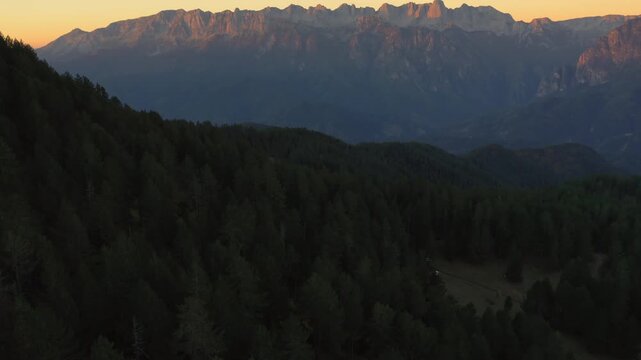 Tranquil sunrise over Pindus mountain range in Epirus, Greece, golden light across forested slopes
