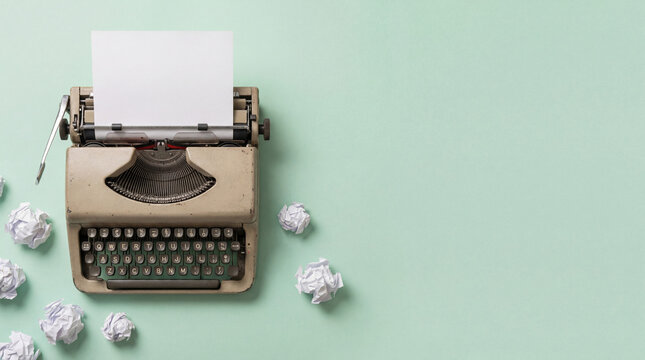 Classic typewriter with blank paper and crumpled sheets on soft background symbolizing writing process