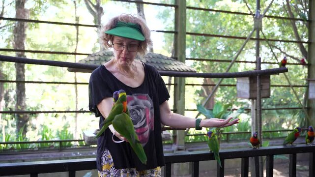 Tourist Woman Feeding Colorful Lorikeet Parrots At Kuala Lumpur Bird Park Malaysia