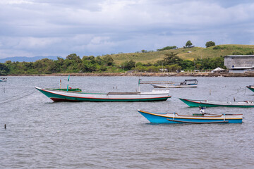 Fototapeta premium Traditional Colorful Fishing Boats Anchored in the Calm Waters of Sumbawa Coast, Indonesia.