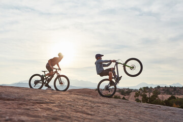 Fototapeta premium Mountain bike, men and adventure for training, travel and extreme sports with hobby. Sunshine, healthy people and friends with practice, balance or journey to explore, adrenaline or power performance