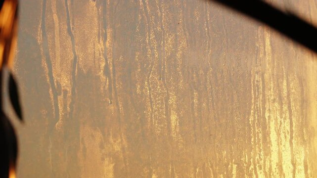 Dirty and dusty dark window glass in the sunset. Abstract dirty window glass background. Window with very dirty and dusty glass in daylight in the sunset. Condensation on the fogged windows glass.