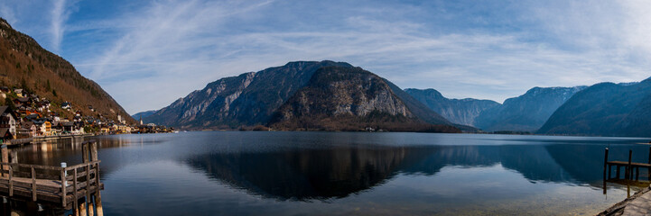 Fototapeta premium Panoramic view of alpine lake with mountain reflections and dramatic cliffs in Austria