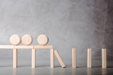 Multiple objects placed on a wooden structure that cannot proceed due to a broken link, representing bottleneck, system overload, inefficiency, and failure in process or operations