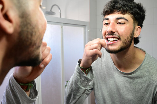 Male model demonstrating proper interdental brushing technique for oral care