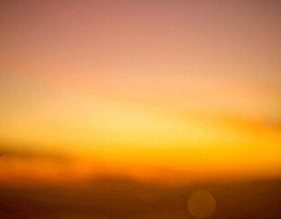 Fototapeta premium 海辺の夕陽のオレンジ色の空のぼやけた背景