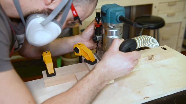 Wood router in action cutting into a wooden surface. The spinning bit carves a precise groove as the tool is guided smoothly across the material.