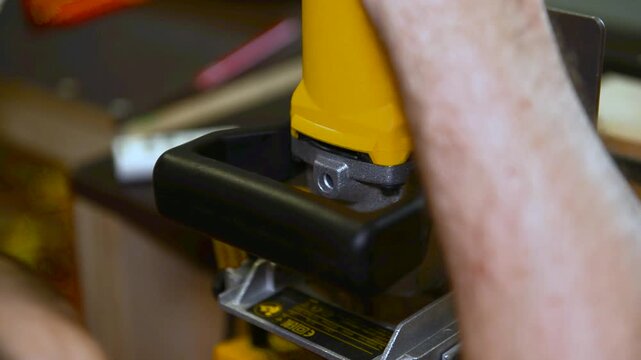 Wood lamella router in action cutting into a wooden surface. The spinning bit carves a precise groove as the attachment cutting into the material.