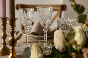 Fotobehang Eetkamer Elegant crystal glasses on a rustic linen table with gold candlesticks and soft floral arrangements. Perfect for festive celebrations, weddings, and sophisticated dinner party settings. Vintage.  © Francis