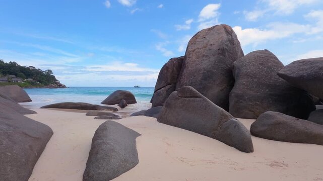 Carana beach, huge granites stones, white sandy beach with calm water, passing boat, Mahe, Seychelles 25fps