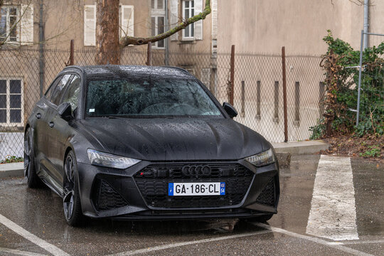 Nancy, France - March 30th 2026 : View on a matte black Audi RS6 Avant C8 with water drops parked on a parking lot under a downpour.