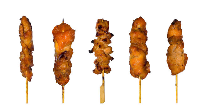 A vibrant photograph showcasing five succulent, perfectly grilled chicken skewers.