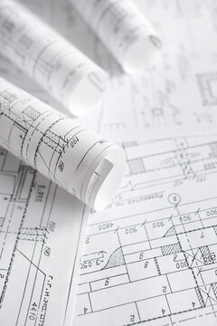 Architecture blueprints with rolled plans, compass and clipboard on desk, construction documentation and engineering design workflow,planning and project management concept, copy space.