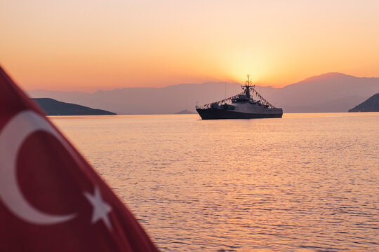 Turkish naval ship dressed with signal flags at sunrise in the bay