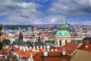 Obraz premium Panoramic view of Prague with St. Nicholas Church, Czech Republic. Historical town under cloudy grey sky in Bohemia