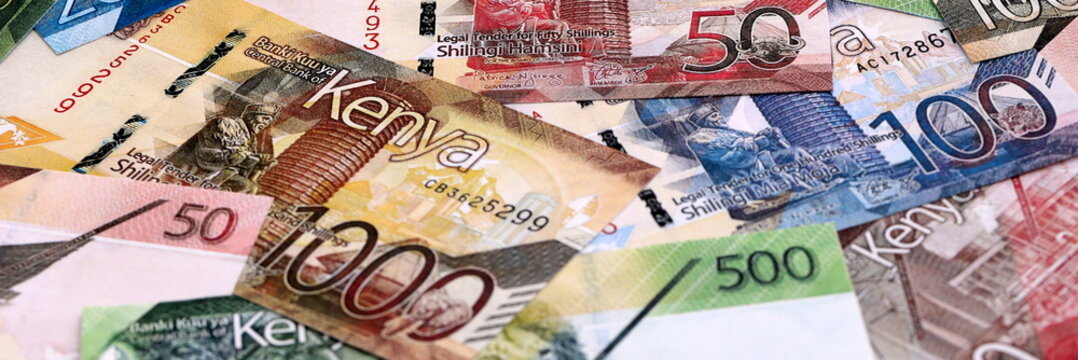 Kenyan shilling money bills pile on table. Kenya banknotes of KES currency close up.