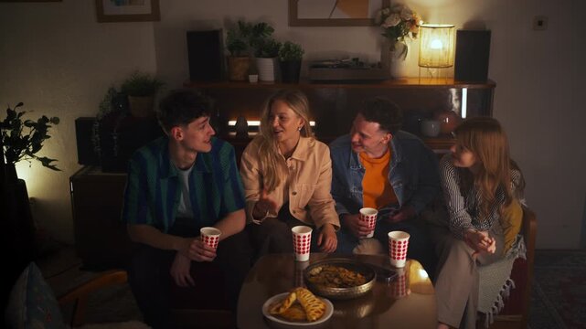 Friends Enjoying Cozy Gathering with Snacks and Drinks in Stylish Living Room