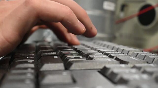 Close up of hands pressing computer keyboard keys in slow motion