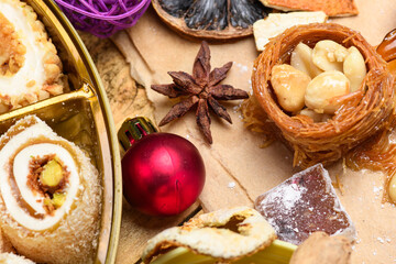 Oriental sweets assortment with pistachios and Christmas ornaments on wooden table