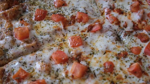 Perfectly baked margherita pizza features vibrant tomato sauce, creamy mozzarella slices, Herbes de Provence and spices.