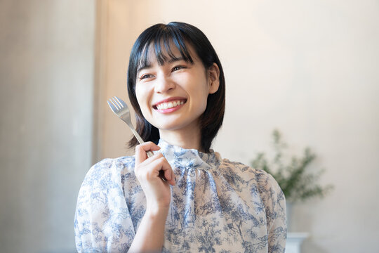 フォークを持って嬉しそうな表情をしている女性