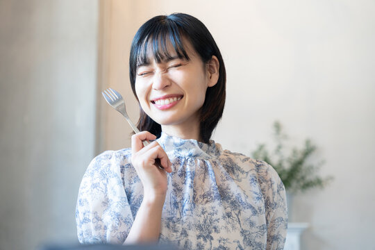 フォークを持って嬉しそうな表情をしている女性