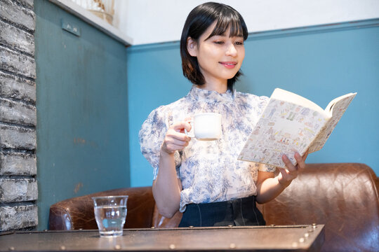 カフェで本を読んでいる笑顔の女性