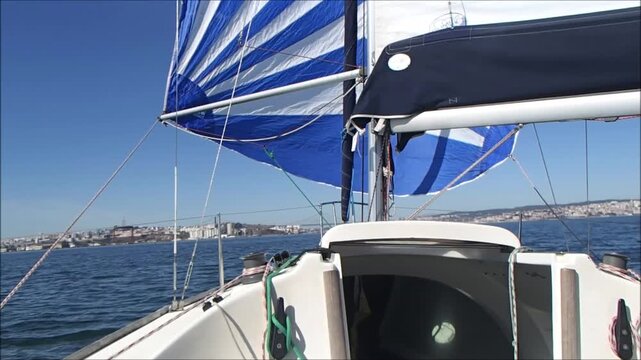 Sailing on a calm sea with city skyline in the background