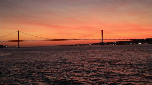 Breathtaking sunset over the iconic bridge in Lisbon, Portugal