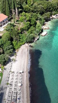 Barbati Beach, Corfu Island: Incredible turquoise water and white pebbles. Beautiful Greek coastal landscape with Mount Pantokrator in the background, perfect for summer travel themes.