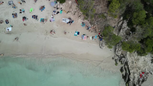 Aerial drone top view over a beach with clean turquoise water at Cala Turqueta, Menorca Island, Balearic islands, Spain