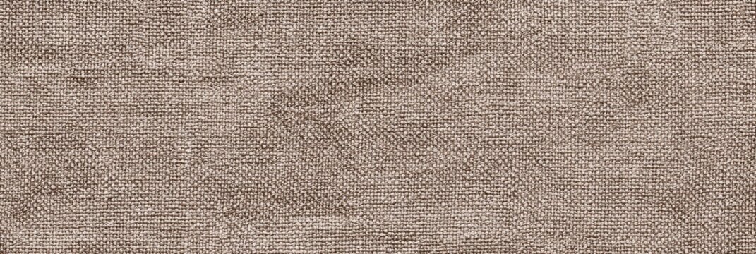 A close-up view of an ecru denim fabric texture with a visible woven pattern and slight pilling on the surface. This neutral textile background is ideal for various design projects.