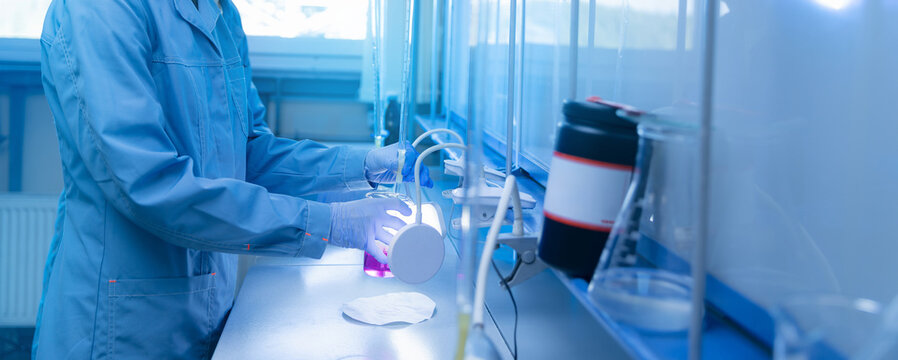 Laboratory technician working with titration apparatus at bench