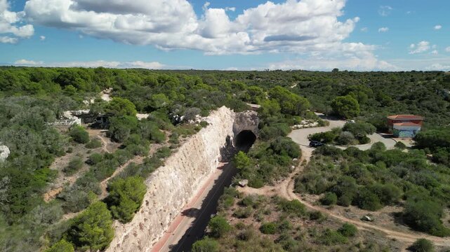 Aerial drone view in the road tunnel to Son Bou beach town. Menorca Island, Balearic islands, Spain. 