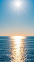 Fototapeta premium Bright sun reflecting on the ocean surface with clear blue sky, sunlight sparkling on water