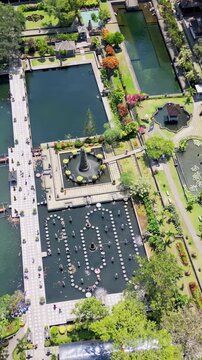 Aerial drone view of Tirta Gangga Water Palace in Karangasem, East Bali, Indonesia. Royal gardens with ornamental ponds, fountains, stepping stones, and traditional Balinese architecture . Vertical