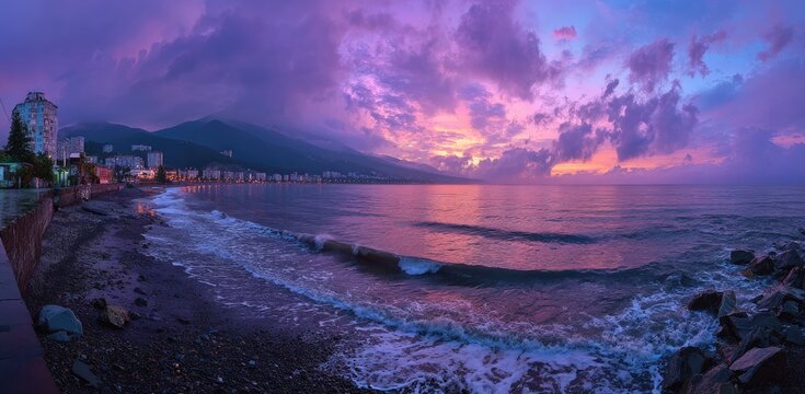 Panoramic view of a coastal city at dusk, with a colorful sunset and the ocean in the foreground