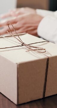 Hands, wrap and person with box in office for logistics, delivery or order package for courier. Service, ecommerce and female entrepreneur with strings for product in workshop for distribution.