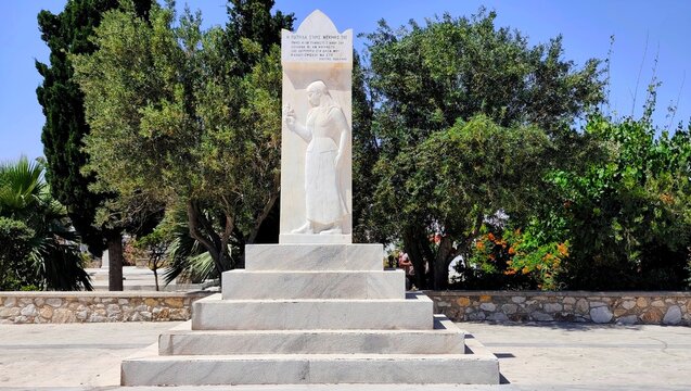 Photo of the marble Cenotaph (War Memorial) in Manto Mavrogenous Square, Paroikia, on the island of Paros, featuring an excerpt from Kostis Palamas poem &ldquo;The Grave&rdquo;.
