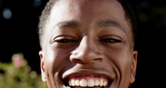 African American man, 20s, responding to camera prompt outdoors smiling then laughing showing studs