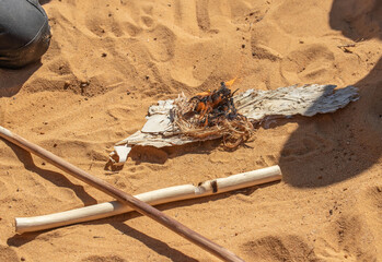 Obraz premium Traditional fire making by friction using wooden sticks in Australian indigenous survival practice
