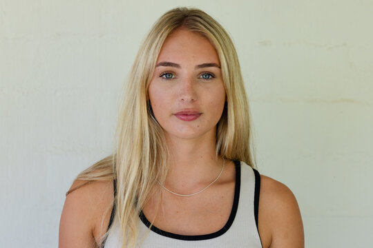 Adult female posing and looking into camera in studio, wearing ribbed tank top and silver chain