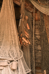 Old fishing nets and floats hanging on wooden wall © Inessa